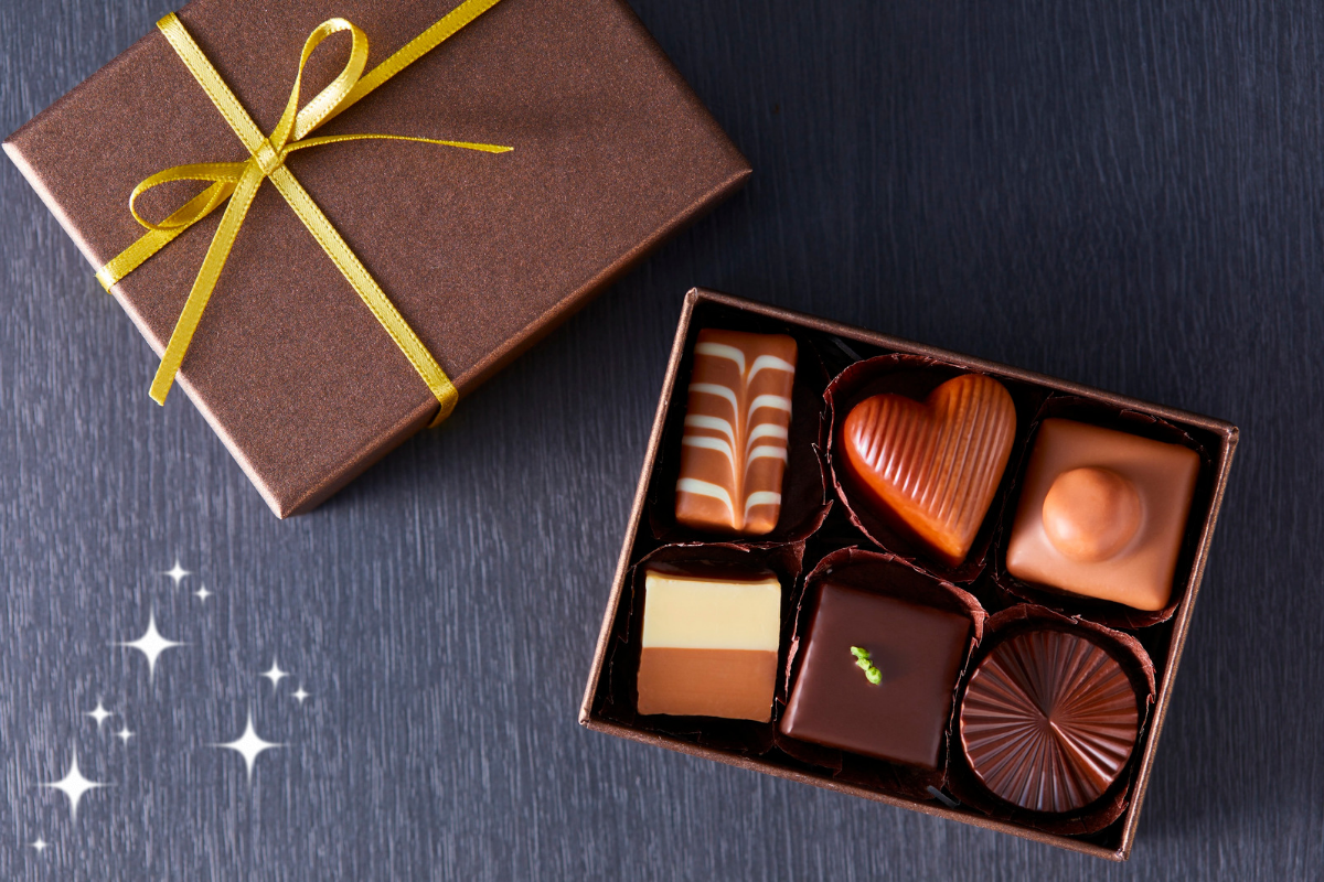 リボン付きのギフト箱とさまざまな種類のチョコレート